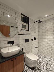 a white bathroom with a sink and a toilet at Evara - stay explore belong in Varanasi