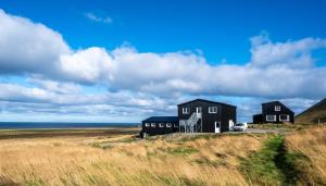 a couple of black houses on the beach at Dis Cottages in Grundarfjordur