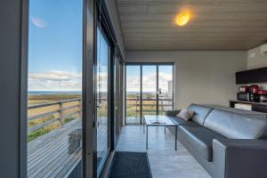 a living room with a couch and a view of the ocean at Dis Cottages in Grundarfjordur