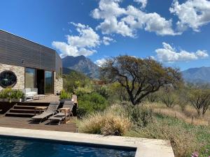 Una casa con piscina con montañas al fondo. en Lodge La campana - Ecological Reserve, en Ocoa