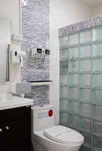 a bathroom with a toilet and a tiled wall at Luxury New Villa 2BR Pool near Bangtao Laguna and Beach in Ban Thalat Choeng Thale