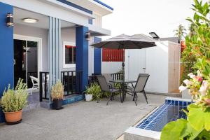 a patio with a table and an umbrella at 2BR Pool Villa near Bangtao Beach and Boat Avenue Private in Ban Thalat Choeng Thale