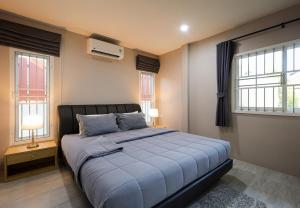 a bedroom with a large bed and two windows at Luxury New Villa 2BR Pool near Bangtao Laguna and Beach in Ban Thalat Choeng Thale +20 photos