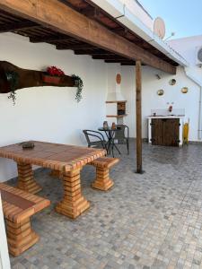 un patio con un banco de madera y una mesa en Cantinho Alentejano, en Oriola