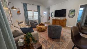 un salon avec un canapé et une télévision dans l'établissement Bella's Charming Cottage, à Thomasville