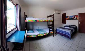 a room with two bunk beds and a table at Ganesha Hostel in Pipa