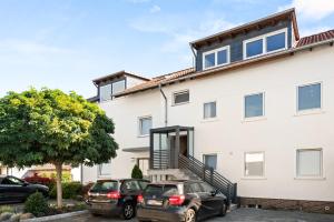 due auto parcheggiate di fronte a una casa bianca di Exklusive 160 qm Wohnung mit Balkon für Gruppen in Guter Lage a Kassel