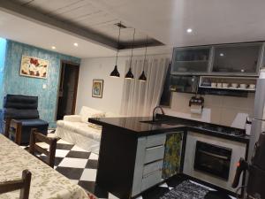 a living room with a kitchen and a couch at Casa do aconchego k&P in Paraty +4 photos