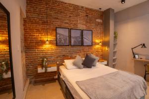 une chambre avec un mur de briques et un lit dans l'établissement Hotel Casa Agena, à Carthagène des Indes