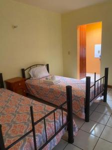 a hotel room with two beds and a night stand at Casa Bonita Centro in Oaxaca City