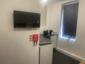 a room with a flat screen tv on a wall at Your Cozy Colne Getaway Free parking and views in Colne +7 photos