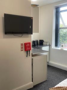 a room with a refrigerator with a tv on the wall at Your Cozy Colne Getaway Free parking and views in Colne