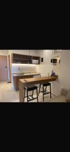 a kitchen with a wooden table and two stools at Gav resort in Salinópolis