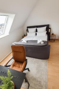 a bedroom with a large bed and a chair at Ferienwohnung in Bad Vilbel mit Parkplatz nahe Messe, Frankfurt und Flughafen in Bad Vilbel