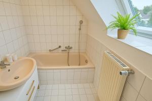 a bathroom with a bath tub and a sink at Ferienwohnung in Bad Vilbel mit Parkplatz nahe Messe, Frankfurt und Flughafen in Bad Vilbel