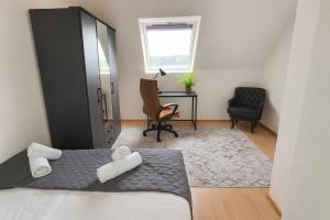 a bedroom with a bed and a desk and a chair at Ferienwohnung in Bad Vilbel mit Parkplatz nahe Messe, Frankfurt und Flughafen in Bad Vilbel