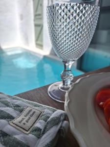 a wine glass sitting on a table next to a plate of food at Casa do Capitão in Monte Trigo