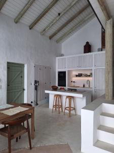 a kitchen with white cabinets and a table and chairs at Casa do Capitão 