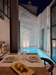 a dining room with a table and a swimming pool at Casa do Capitão in Monte Trigo