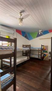 a room with three bunk beds and a ceiling at Ganesha Hostel in Pipa