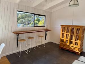 a room with a bar with stools and a window at Sandy Beach Apartment in Russell