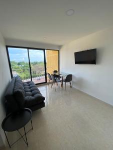 ein Wohnzimmer mit einer Couch und einem Tisch und Stühlen in der Unterkunft Apartamento en bello horizonte in Playa Dormida + 1 Foto