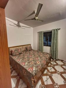 a bedroom with a bed and a ceiling fan at Naini Kalsa Stay in Nainital
