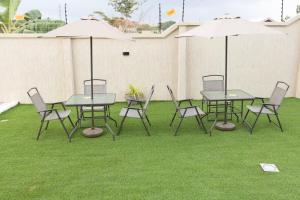 a group of tables and chairs with umbrellas on grass at The Riverdale in Buku