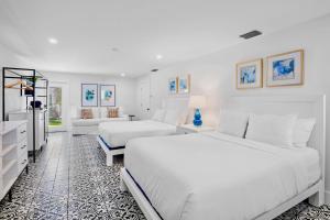 a white bedroom with two beds and a couch at Pelican Post at Anna Maria Island Inn in Bradenton Beach +57 photos