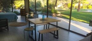 a room with a table and chairs and a view of a yard at Espacio Arenales in Paine