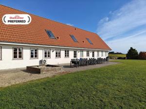 a building with tables and chairs in front of it at 20 person holiday home in Nordborg-By Traum in Nordborg