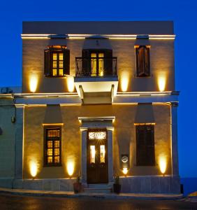 a large white building with lights on it at night at Arion Syros in Ermoupoli
