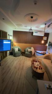 salon z kanapą i telewizorem w obiekcie شقه فندقية الخيال w mieście Dżudda