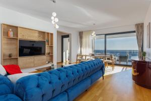 a blue couch in a living room with a view of the ocean at Adriatic Masterpiece Residence in Sveti Stefan +27 photos
