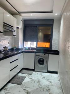 a kitchen with a washing machine and a window at Spacious apartment 5 min walk to the beach in El Jadida