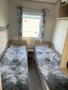 deux lits dans une petite pièce avec une fenêtre dans l'établissement Doniford Bay - Holiday Accommodation 20985, à Watchet