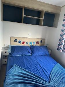 - un lit avec une couette bleue dans une chambre dans l'établissement Doniford Bay - Holiday Accommodation 20985, à Watchet 9 autres photos