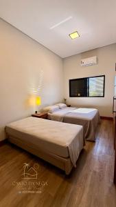 two beds in a bedroom with a window at Canto da Nega - Seu canto na Praia! in Itapoa