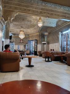 eine Lobby mit einem Mann, der auf einem Sofa und einem Tisch sitzt in der Unterkunft Riad Spa Medina Souks in Marrakesch