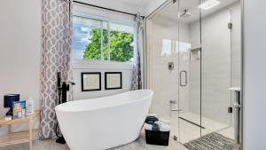 une salle de bain avec baignoire et douche avec fenêtre dans l'établissement R&R Heaven Music 4 the Soul See fall colors Hottub, à Campbellford 29 autres photos