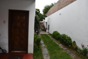 an entrance to a white building with a door and flowers at B&B Villamar Chorrillos in San Antonio