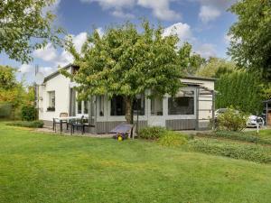 a small white house with a tree in the yard at Nelsen mit Ruderboot auf Wassergrundstück in Jabel
