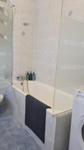 a bathroom with a bath tub and a sink at CENTRaL Gem 3Bdr, Balcony &Views in Gibraltar +27 photos