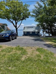 ein blaues Haus mit einem davor geparkt in der Unterkunft Year-round Cozy Cottage Charm on Cayuga Lake in Romulus + 31 Fotos