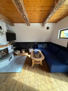 un soggiorno con un divano blu e una TV di Chata Teplička - Relax v súkromnej kúpacej kadi a Teplička