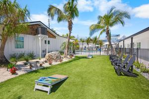 a row of benches on a lawn with palm trees at Pelican Post at Anna Maria Island Inn in Bradenton Beach