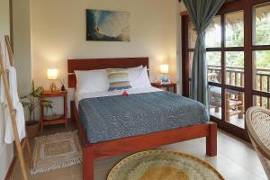 a bedroom with a bed and a balcony at Surfista Villa Siargao in General Luna
