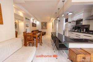 eine Küche und ein Esszimmer mit Tisch und Stühlen in der Unterkunft Apto Praia das Pitangueiras com Piscina aquecida in Guarujá