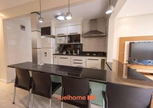 eine Küche mit einer großen schwarzen Arbeitsplatte in einem Zimmer in der Unterkunft Apto Praia das Pitangueiras com Piscina aquecida in Guarujá