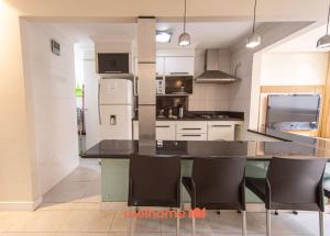 eine Küche mit Tisch und Stühlen und einem Kühlschrank in der Unterkunft Apto Praia das Pitangueiras com Piscina aquecida in Guarujá